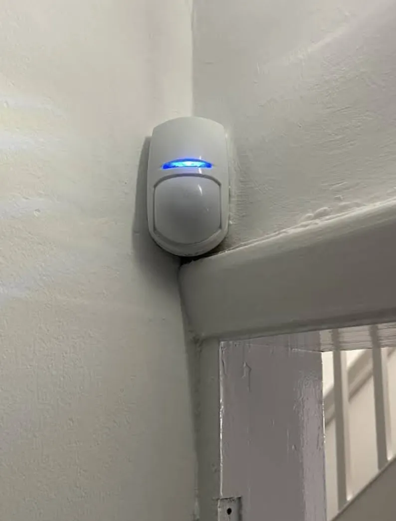 Wireless alarm motion sensor in a hallway