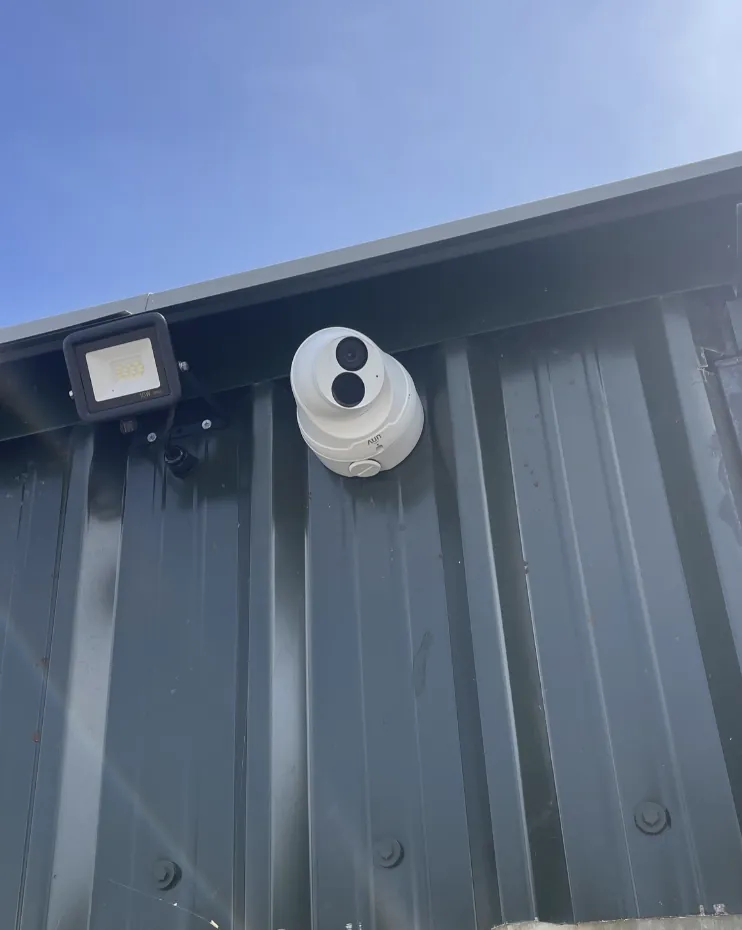 CCTV camera and floodlight installed on a steel clad commercial building