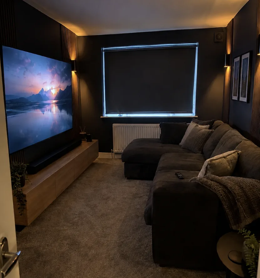 Home cinema room with wall mounted TV and drop down projector screen